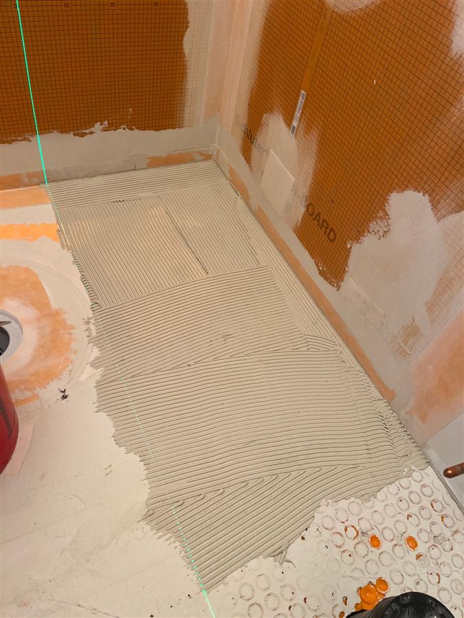 Combed mortar bed with a laser line ready for tile
